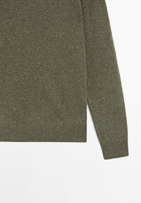 Maglione verde oliva con polsini e orlo a coste, realizzato in un morbido tessuto testurizzato, con collo a giro e maniche lunghe.
