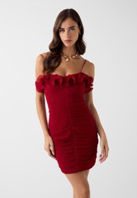 Rotes, tailliertes Kleid mit gerafften, schulterfreien Ärmeln. Strukturierter Stoff mit Falten. Verstellbare Spaghettiträger. Betonende Silhouette.