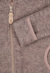 Fleece zip-up jakke i dempet mauve, med metallglidelås, kontraststing og en sirkulær lomme med en jevn tekstur.
