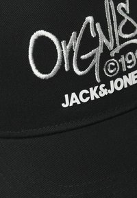 Gorra negra con el texto bordado en blanco "Original" y el logo "JACK&JONES", con un diseño estructurado y tela texturizada.