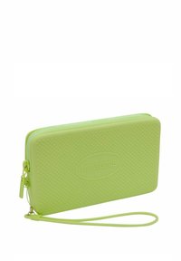 Cartera de goma verde con un patrón texturizado, cierre de cremallera y correa para la muñeca. Cuenta con un logo embosado circular en la parte frontal.