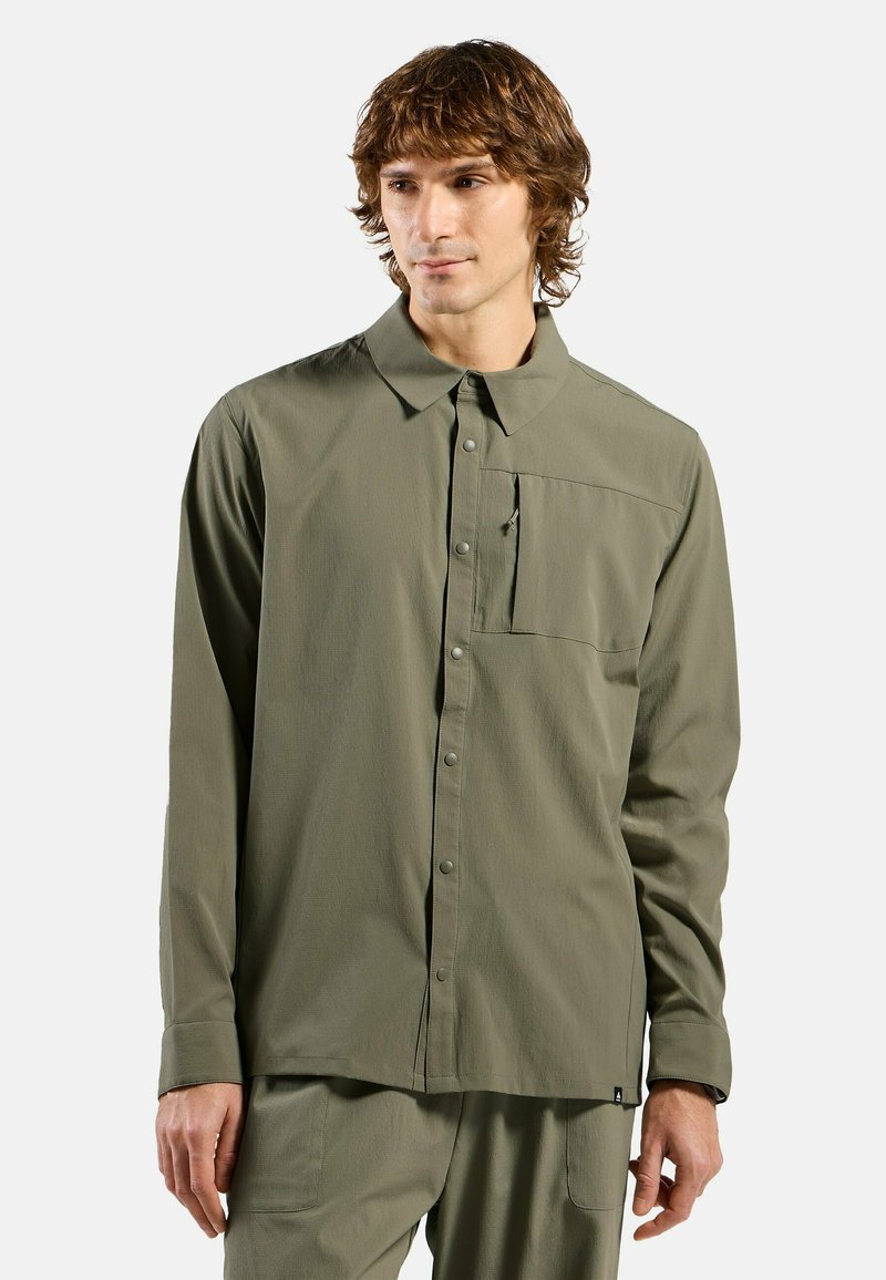 Grünes Langarmhemd aus leichtem Stoff, mit Knopfverschluss, Kragen und einer Brusttasche mit einem kleinen Reißverschlussdetail.