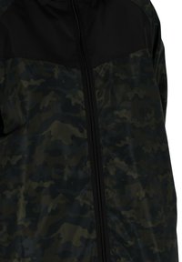 Jachetă de camuflaj cu o secțiune superioară neagră. Fabricată dintr-un material ușor, cu un finisaj strălucitor, având un fermoar central și o textură netedă.