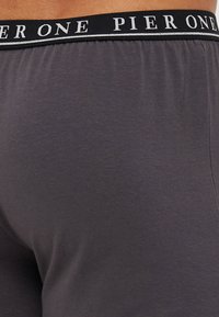 Graue Stretch-Shorts mit einem schwarzen Bund, auf dem "PIER ONE" in weißen Buchstaben steht. Weicher Stoff mit glatter Textur und enganliegender Form.