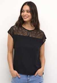 Black short-sleeve top with a lace design on the chest and shoulders, featuring a round neckline and a button detail at the front.