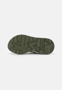 Sole zelených tenisek v olivové barvě s geometrickým a texturovaným vzorem dezénu, s nápisem "PUMA RS-X" blízko středu.