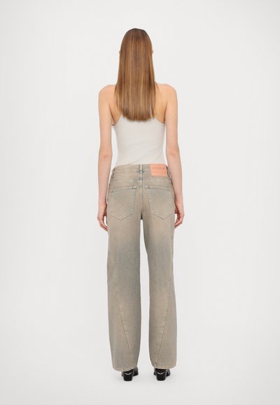 Helle graue weite Jeans mit einem gewaschenen Finish, ausgestattet mit einem rosa Markenschild am Bund und zwei Gesäßtaschen.