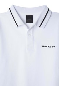 Biała koszulka polo z teksturowanej tkaniny, z klasycznym kołnierzykiem w czarne paski oraz małym czarnym logo "HACKETT" na piersi.