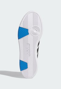 Bijela gumena potplat s teksturiranim uzorkom, crnim akcentima i plavim gumenim umetkom s kružnim i točkastim detaljima.