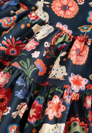 Kangas dengan pola floral yang memiliki latar belakang navy gelap menampilkan bunga besar berwarna merah, pink, dan biru, serta motif hewan yang whimsical. Tekstur berkerut.