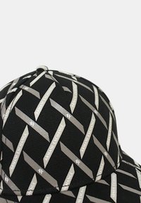 Cappellino nero realizzato in tessuto testurizzato, con un motivo ripetuto in argento "Armani Exchange" in strisce diagonali.
