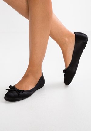 Czarne baleriny wykonane z gładkiego materiału, z zaokrąglonym noskiem i małą kokardką na cholewce, z płaską podeszwą.