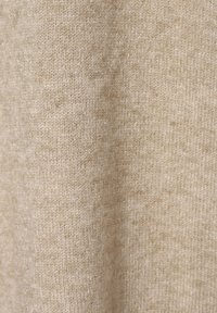 Beżowa dzianina o miękkiej fakturze, z delikatnym wzorem w różnych odcieniach, tworząca ciepły, neutralny wygląd.