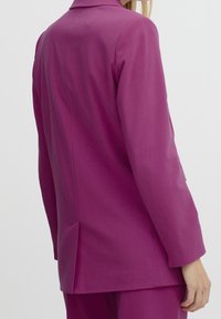 Fuchsia skräddarsydd kavaj med klandestinerad krage, enkel sprund och slät tyg. Skuren för en skräddarsydd passform med långa ärmar.