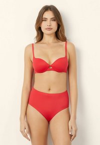 Completo bikini rosso con reggiseno imbottito e spalline regolabili, accompagnato da uno slip a vita alta. Tessuto morbido ed elastico con decorazioni minime.