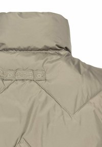 Beige polstret jakke med høj krave, der har et diagonalt quiltet mønster og en label med teksten "camel active" på ryggen.