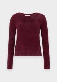 Hosszú ujjú, bordó bolyhos pulóver kerek nyakkivágással, fehér háttéren elhelyezve.