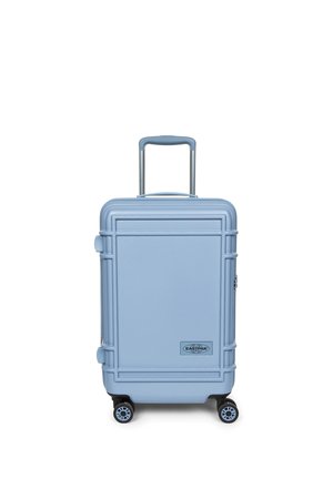 Valigia rigida azzurro chiaro con quattro ruote, manico telescopico e logo Eastpak al centro davanti.