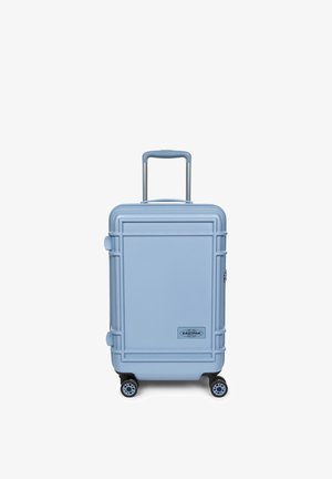 Valise rigide bleu clair avec quatre roues, une poignée télescopique et le logo Eastpak au centre à l'avant.