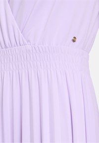 Lavendelfarbenes Kleid mit gerafftem Bund, das vertikale Falten und ein dekoratives goldenes Knopfdetail an der Seite aufweist. Weicher, glatter Stoff. 