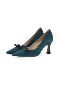 Décolleté in suede color turchese con tacco a spillo e punta affusolata, adornati da un fiocco sulla tomaia, dotati di un tacco slanciato e un sottopiede beige liscio.