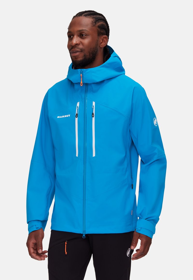 Blaue wasserdichte Jacke mit Kapuze, die zwei weiße Reißverschluss-Fronttaschen, verstellbare Manschetten und einen orangefarbenen Reißverschluss-Zieher aufweist.