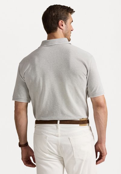 Siva polo majica s ovratnikom, kratkimi rokavi in teksturirano tkanino, v kombinaciji z belimi hlačami in rjavim pasom.