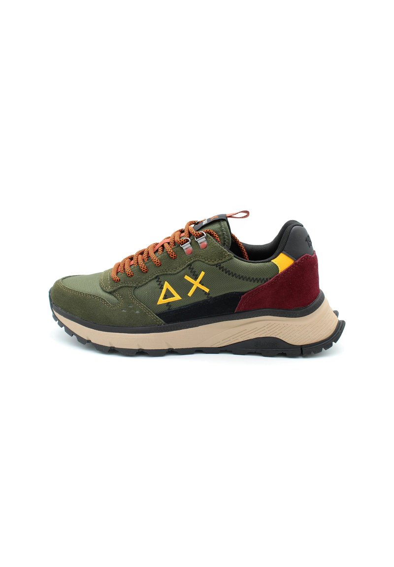 Sneakers verde in suede e tessuto con lacci arancioni, dettagli neri e bordeaux, e una robusta suola beige. Presenta un design di logo distintivo.