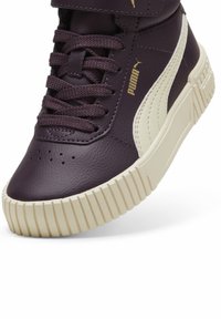 PUMA vysoké tenisky vo tmavofialovej koži s béžovou gumovou podrážkou. Obsahuje suchý zips a textúrovaný povrch na podrážke.