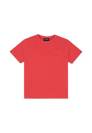 T-shirt rouge à manches courtes avec col rond, logo discret "WRSTBHVR" sur la poitrine gauche et étiquette noire à l'intérieur du col.