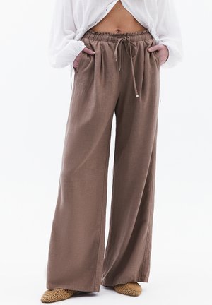 Braune weite Hosen mit einem elastischen, Bindebandbund. Hergestellt aus einem leichten Material mit einer subtilen Textur.
