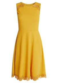 Žluté bezramínkové šaty s přiléhavým korzetem a rozšířenou sukní. Obsahují krajkový lem na ramenou a zvlněný krajkový lem. Hladká textura tkaniny.