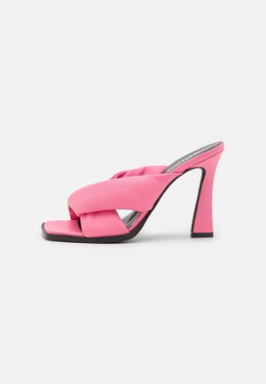 Pink højhælet mule-sandal med brede polstrede krydsremme og firkantet tå på hvid baggrund.