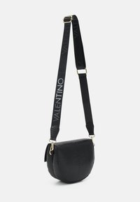 Černá kožená crossbody taška s texturovaným hadím vzorem, zlatým kováním a ramenním popruhem s nápisem "VALENTINO" ve šedé barvě.