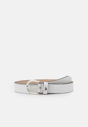 Biały skórzany pasek ze srebrną klamrą, częściowo zwinięty na gładkim białym tle.