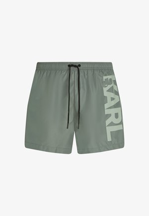 Bañador gris con cordón negro y gran texto en gris claro "KARL" impreso verticalmente en la pierna izquierda.