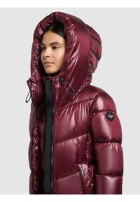 Vīnogu krāsas pufota jaka ar lielu kapuci, spīdīgu virsmu, melnu rāvējslēdzēja detaļu un logotipu uz piedurknes, paredzēta siltumam un komfortam.