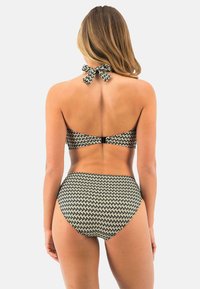 Bikini set met een halternekdesign met een strik, zwart en beige geometrisch patroon en een high-waisted onderkant. Zacht materiaal.