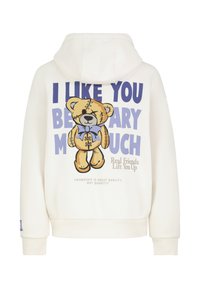 Cremefarbener Hoodie mit einer Cartoon-Teddybär-Grafik, die Nähte und eine Schleife zeigt. Der Text über dem Bären lautet "I LIKE YOU BEARY MUCH".