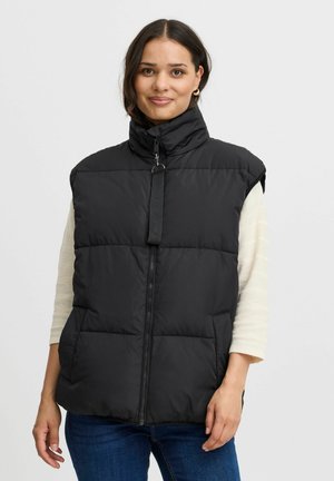 Schwarz gepolsterte Weste mit hohem Kragen, Reißverschluss und Seitentaschen. Hergestellt aus einem glatten, leichten Stoff. Verfügt über sichtbare Nähte und ein minimalistisches Design.