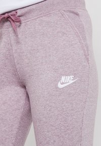 Ljuslila Nike sweatpants i mjukt tyg, med framfickor och elastisk midja med en vit logotypdetalj.