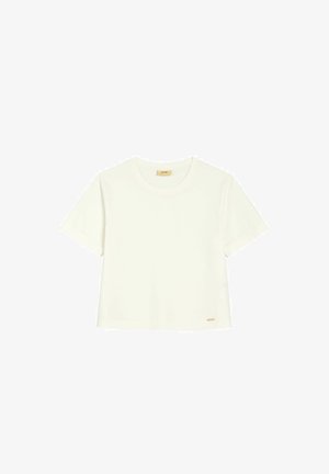 Prosty biały bawełniany t-shirt z krótkim rękawem i okrągłym dekoltem, z małą beżową metką blisko dolnego brzegu, na białym tle.