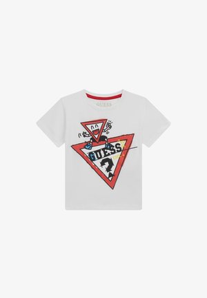 Valge T-särk, kus on mänguline disain naeratava kolmnurga tegelasega, punane kolmnurkne logo ja julged mustad tähed "GUESS."