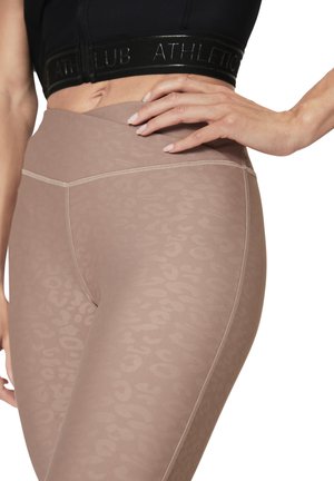 Stretchy, muted beige leggings with a subtle animal print, featuring flat seams and a high waistband for a smooth fit.