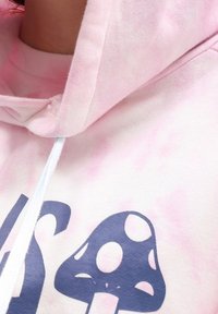 Felpa con cappuccio in tie-dye rosa, caratterizzata da una grafica blu navale di un fungo. Presenta un cordoncino con punte azzurro chiaro e una superficie morbida.