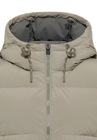 Hellbeige Steppjacke mit Reißverschluss vorne, Kordelzugkapuze und glatter Textur. Gepolstertes Design mit horizontalen Nähten.