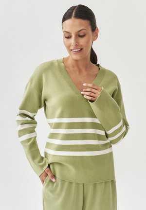Green knit sweater with V-neck, featuring white horizontal stripes. Soft texture and relaxed fit, long sleeves with ribbed cuffs.