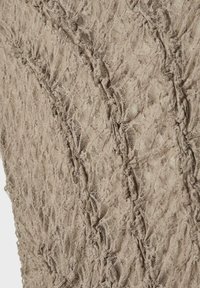 Beige blondelærred med et struktureret mønster, der har forhøjede områder og indviklede designs, hvilket skaber et lagdelt, blødt udseende.
