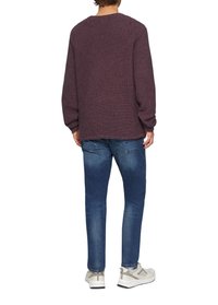 Czerwony sweter dzianinowy z teksturowanymi paskami, luźny krój, okrągły dekolt, w połączeniu z niebieskimi dżinsami i jasnymi trampkami. Widok z tyłu.