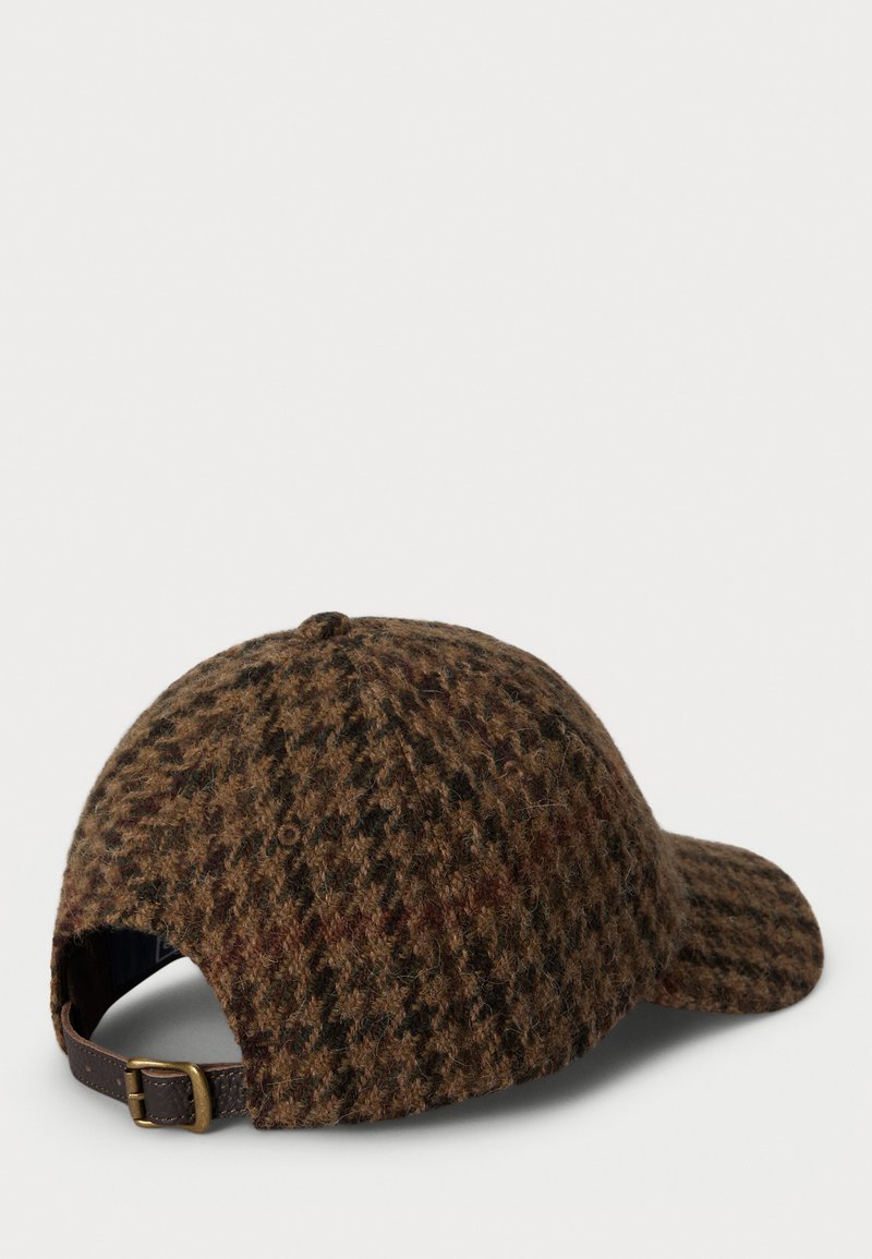 Brauner Wollhut mit Schachbrettmuster, gebogenem Schirm und Lederbandverschluss auf der Rückseite. Strukturiert Oberfläche mit reichhaltigen Farbvariationen.